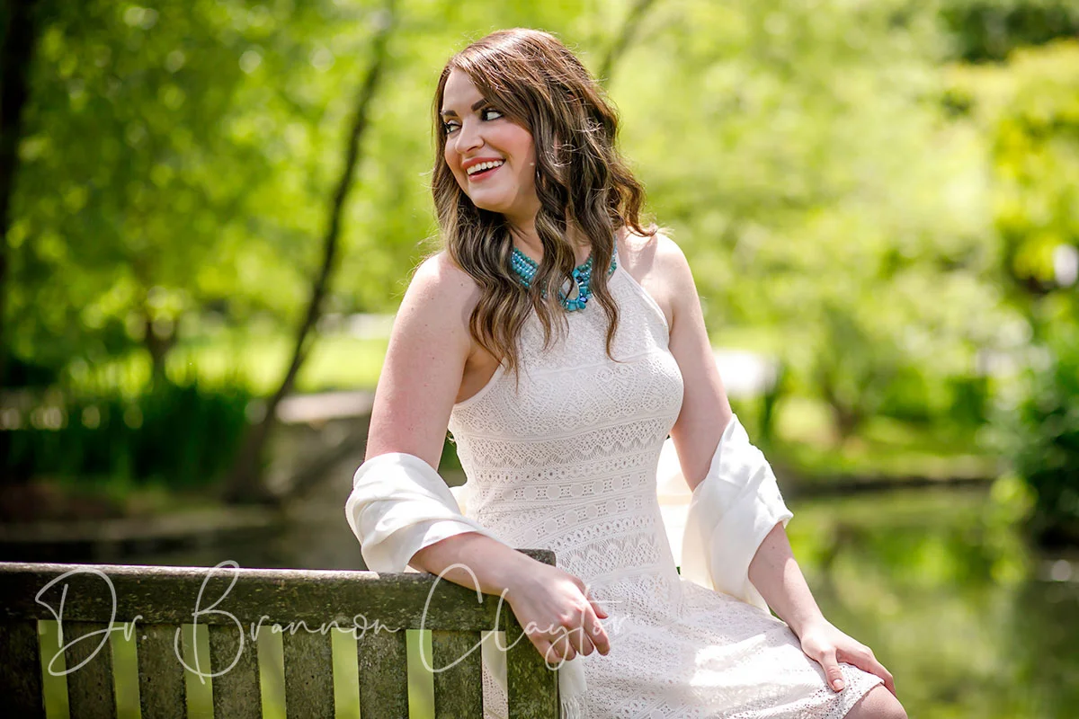 Woman in white dress smiling, an actual Philadelphia plastic surgery patient
