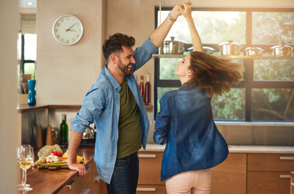Man and woman happily dancing at home