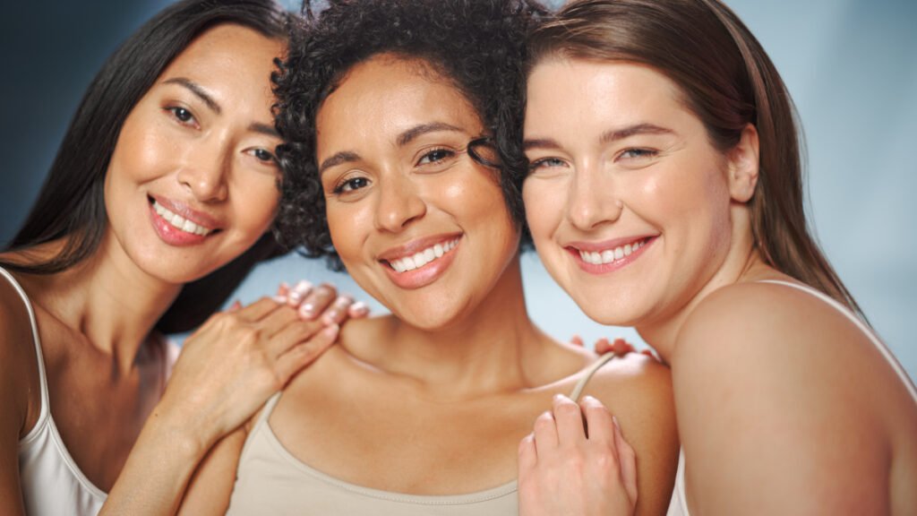 Three women smiling with glowing skin following a Philadelphia HydraFacial treatment