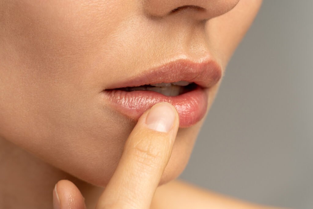 Woman touching her lips after a lip lift with a board certified plastic surgeon